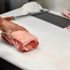 Butcher tying meat on chopping board sq